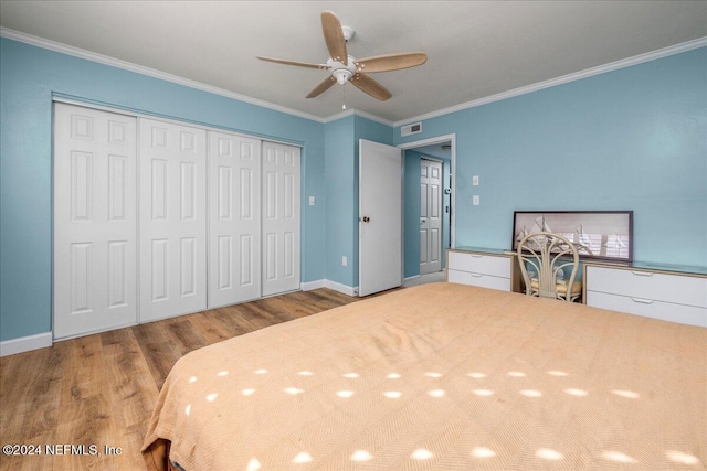 unfurnished bedroom with ceiling fan, light hardwood / wood-style flooring, crown molding, and a closet