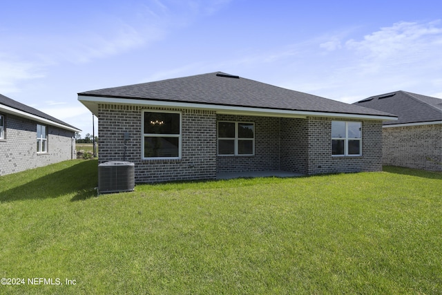 rear view of house featuring a yard and central AC