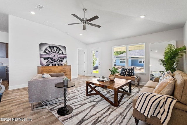 living room featuring ceiling fan, light wood-type flooring, and vaulted ceiling