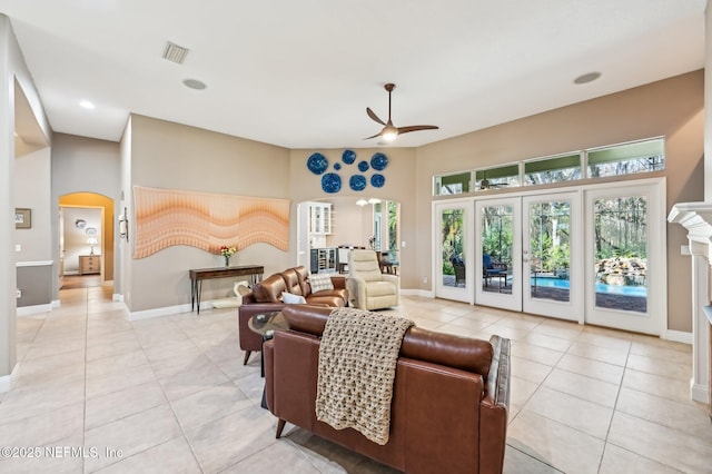 tiled living room with french doors and ceiling fan