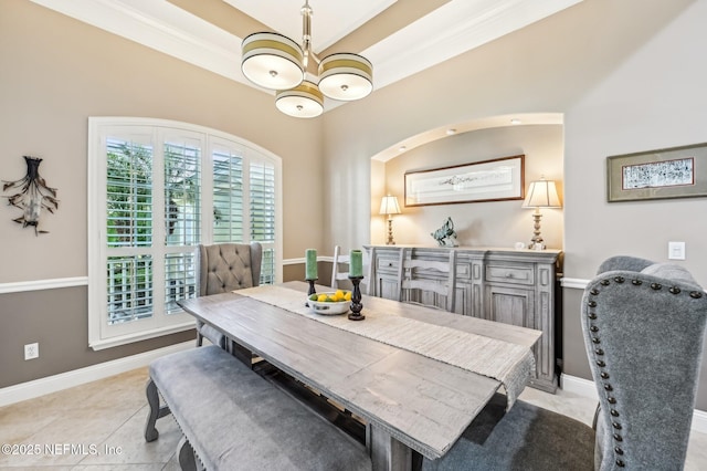 tiled dining room with crown molding and an inviting chandelier