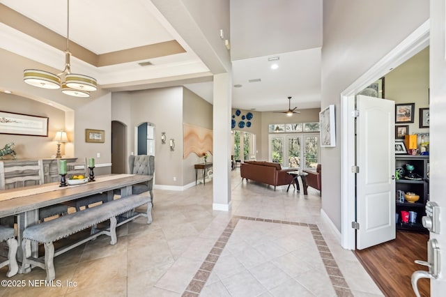 dining area with french doors, light tile patterned floors, and ceiling fan with notable chandelier