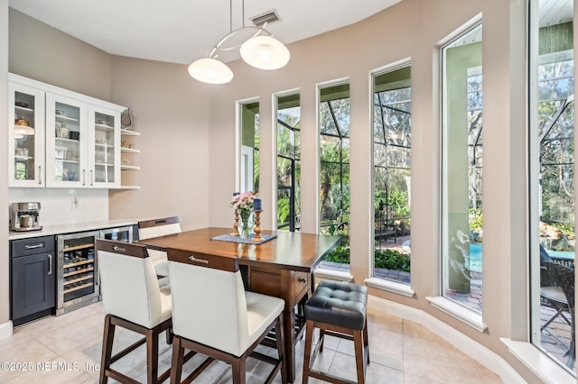 tiled dining space with beverage cooler and indoor bar