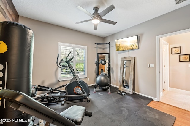 exercise area with ceiling fan and a textured ceiling