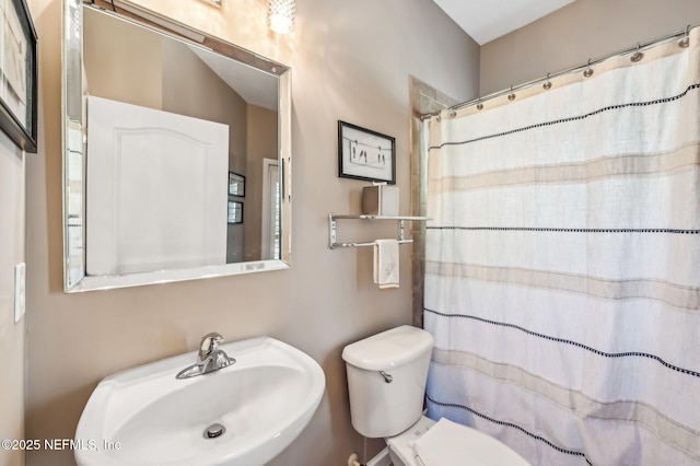 bathroom featuring a shower with curtain, sink, and toilet