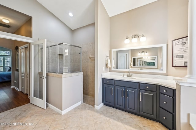 bathroom featuring a tile shower, ornate columns, high vaulted ceiling, tile patterned floors, and vanity