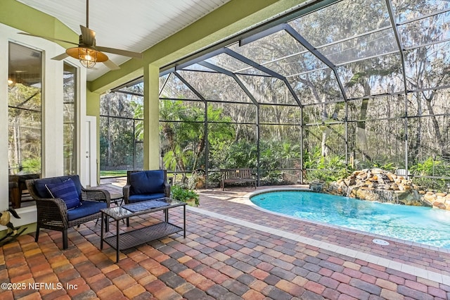 view of pool featuring pool water feature, glass enclosure, ceiling fan, and a patio area