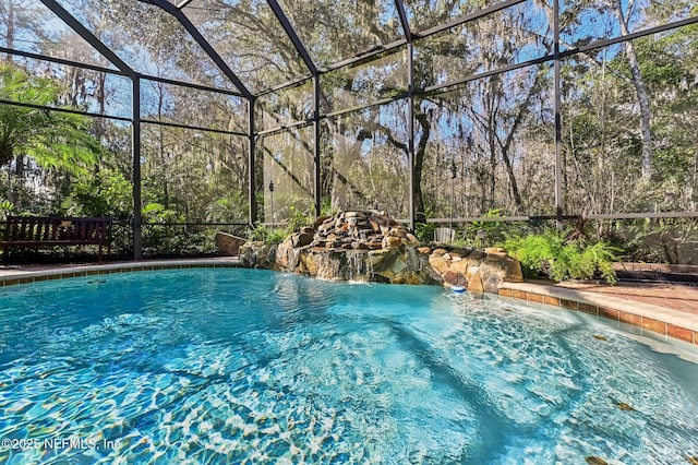 view of swimming pool featuring pool water feature and glass enclosure