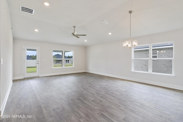 empty room featuring a textured ceiling, ceiling fan with notable chandelier, and hardwood / wood-style flooring