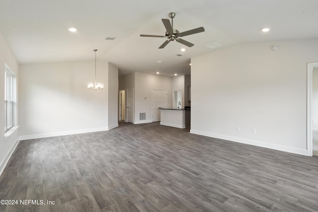 unfurnished living room with ceiling fan with notable chandelier, dark hardwood / wood-style flooring, and lofted ceiling