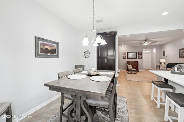 tiled dining room with ceiling fan with notable chandelier