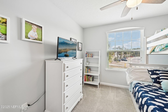 bedroom with a textured ceiling, light colored carpet, and ceiling fan