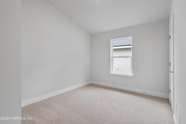 unfurnished room featuring carpet flooring and vaulted ceiling