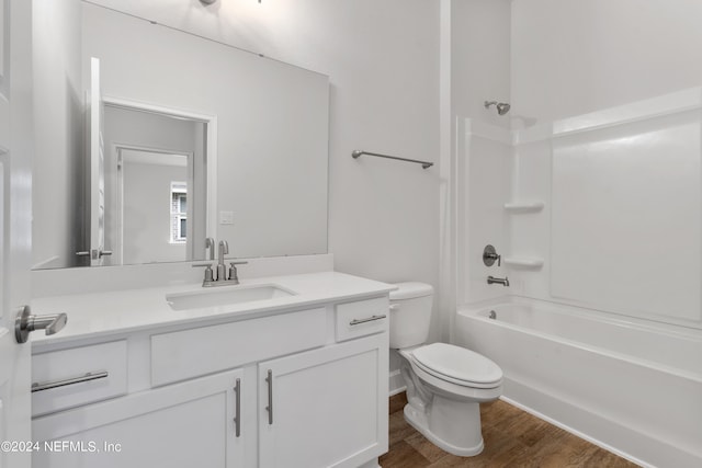 full bathroom with vanity, wood-type flooring, shower / bathtub combination, and toilet