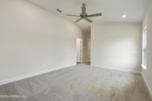 spare room featuring ceiling fan, light colored carpet, and vaulted ceiling