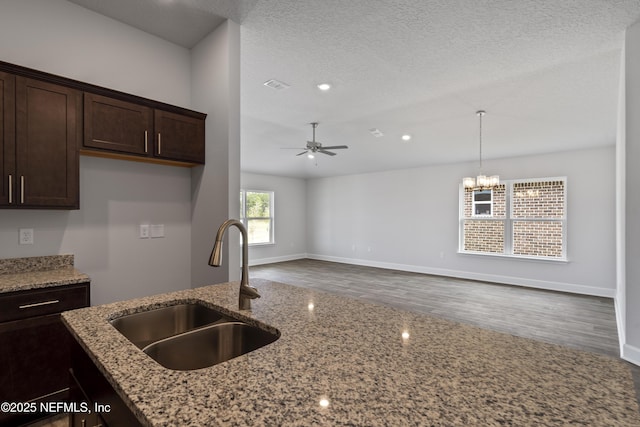3245 Winding Creek Pl, Green Cove Springs, FL 32043 - kitchen with a textured ceiling, a sink, visible vents, light stone countertops, and dark brown cabinets