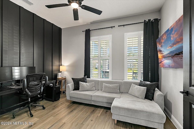 home office with ceiling fan, a textured ceiling, and light hardwood / wood-style flooring