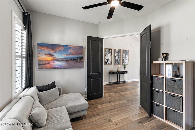 sitting room featuring a textured ceiling, hardwood / wood-style flooring, plenty of natural light, and ceiling fan