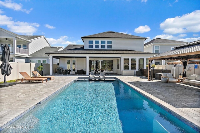 rear view of property featuring a fenced in pool, outdoor lounge area, french doors, and a patio