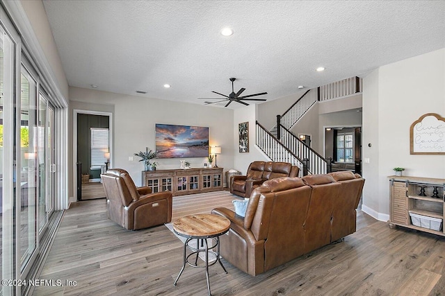 living room with a textured ceiling, light hardwood / wood-style floors, and plenty of natural light