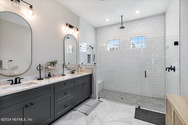 bathroom with a textured ceiling, vanity, and walk in shower