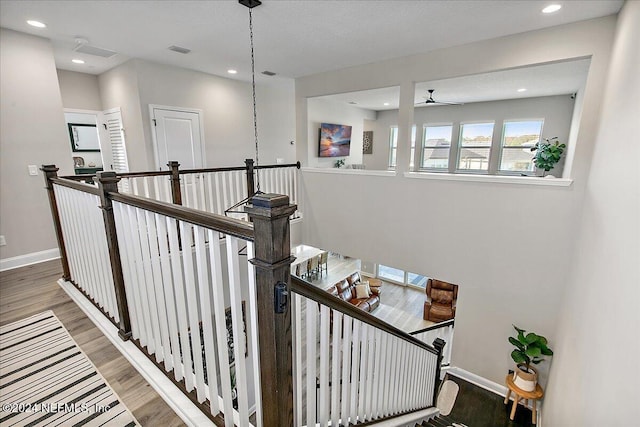 stairs featuring ceiling fan, a textured ceiling, and hardwood / wood-style flooring