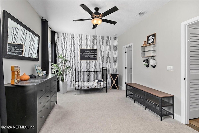 living area featuring ceiling fan, light colored carpet, and a textured ceiling