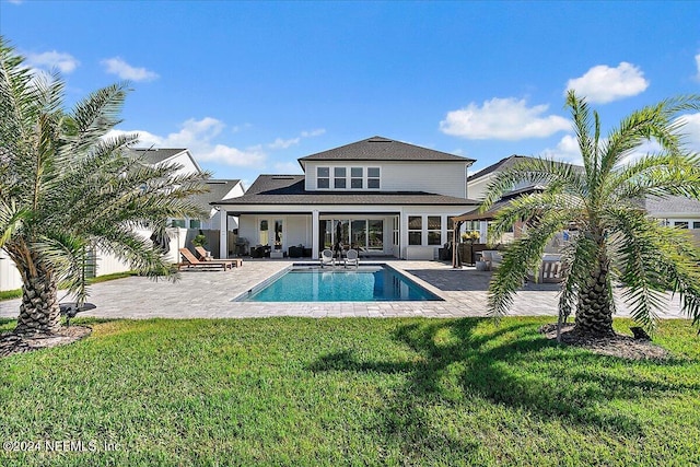 rear view of property featuring a lawn, a patio area, and outdoor lounge area