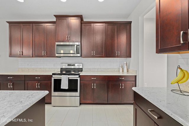 kitchen featuring appliances with stainless steel finishes, backsplash, and light stone counters