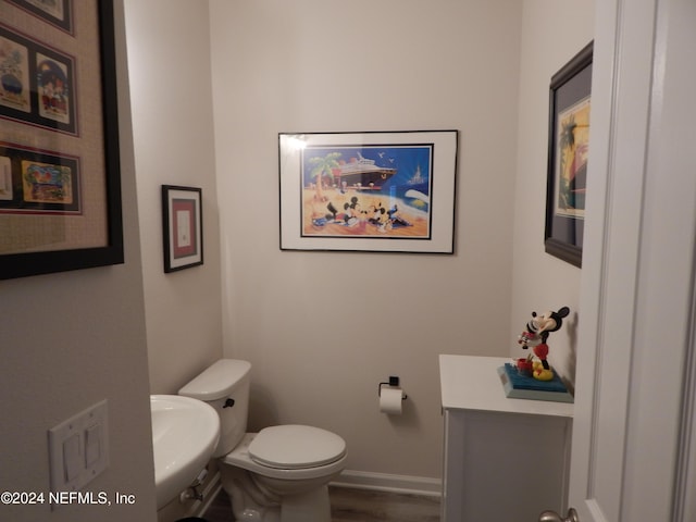 bathroom with hardwood / wood-style flooring, sink, and toilet