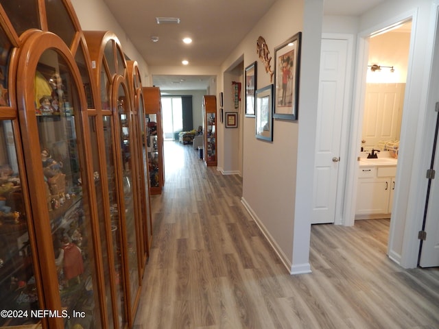 corridor with sink and hardwood / wood-style flooring