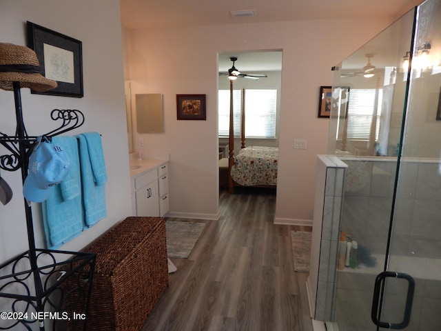 bathroom featuring ceiling fan, wood-type flooring, walk in shower, and vanity