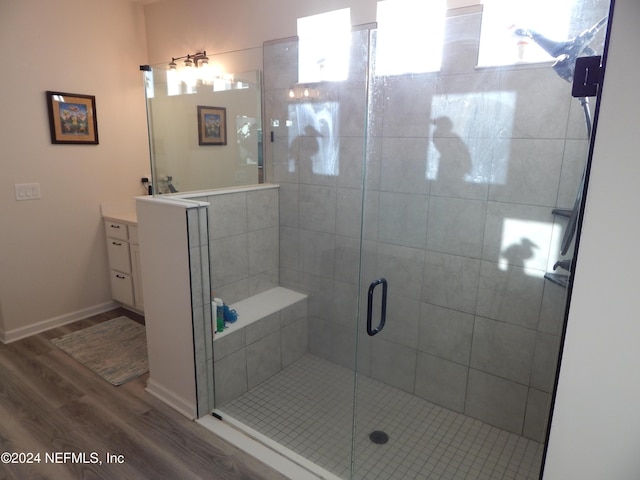 bathroom with vanity, hardwood / wood-style flooring, and a shower with shower door