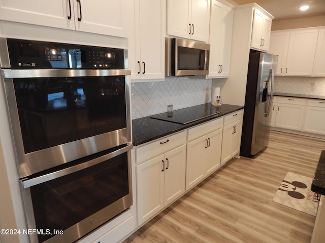 kitchen featuring white cabinets, decorative backsplash, light hardwood / wood-style floors, and appliances with stainless steel finishes