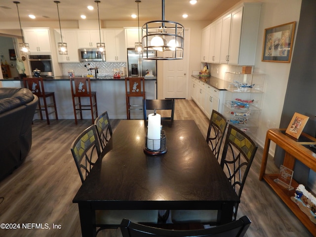 dining area featuring wood-type flooring and an inviting chandelier