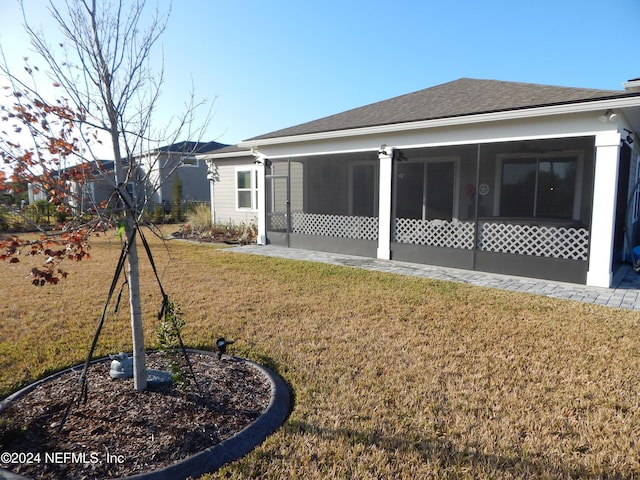 rear view of property with a sunroom and a yard