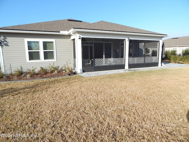 rear view of property featuring a sunroom and a yard