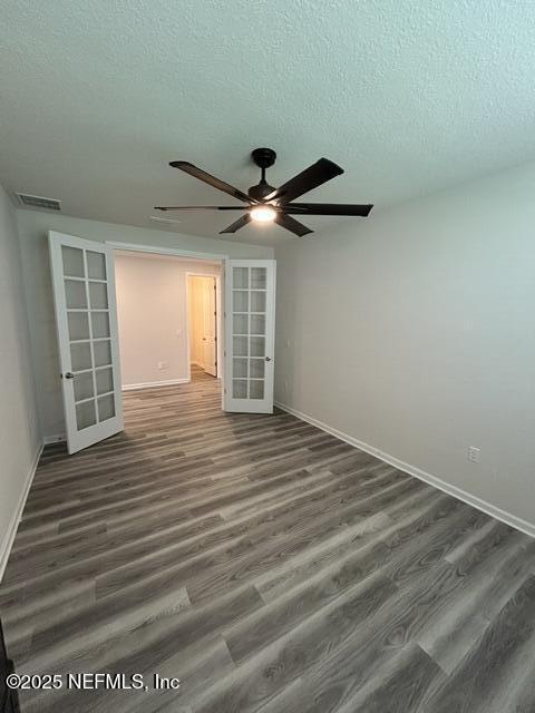 85431 Apple Canyon Ct, Fernandina Beach, FL 32034 - empty room featuring french doors, wood finished floors, a ceiling fan, and a textured ceiling