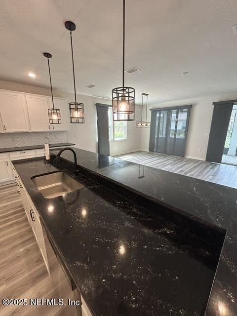 85431 Apple Canyon Ct, Fernandina Beach, FL 32034 - kitchen featuring healthy amount of natural light, white cabinets, light wood finished floors, and decorative backsplash