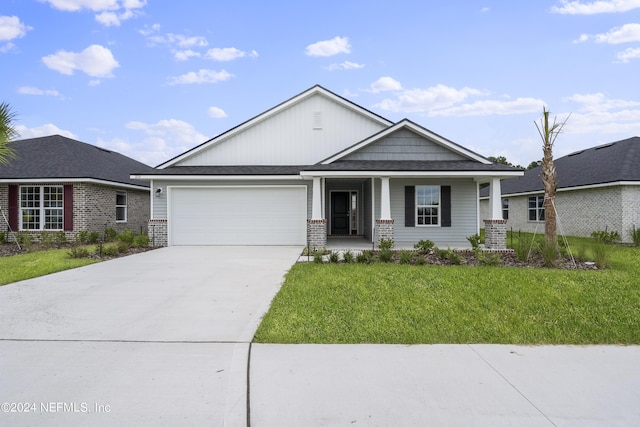 view of front of home with a porch, a garage, and a front lawn