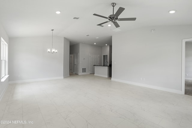 unfurnished living room featuring vaulted ceiling and ceiling fan with notable chandelier