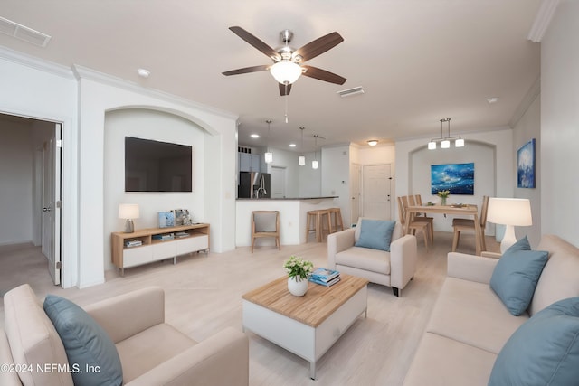 living room featuring ceiling fan, light wood-type flooring, and ornamental molding