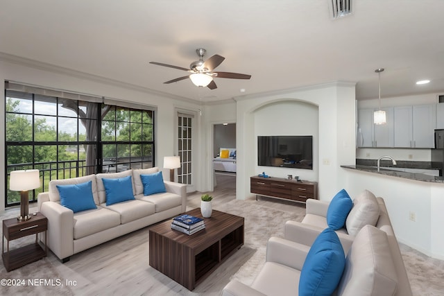 living room featuring ceiling fan and ornamental molding