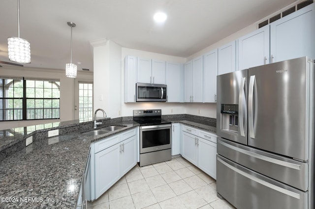 kitchen featuring white cabinets, appliances with stainless steel finishes, pendant lighting, and sink