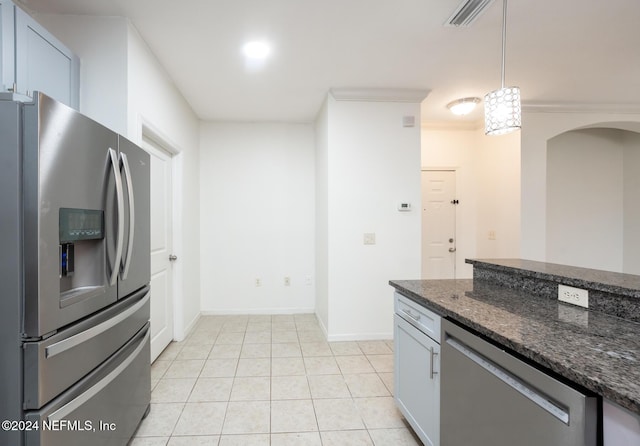 kitchen featuring white cabinets, crown molding, dark stone countertops, appliances with stainless steel finishes, and decorative light fixtures