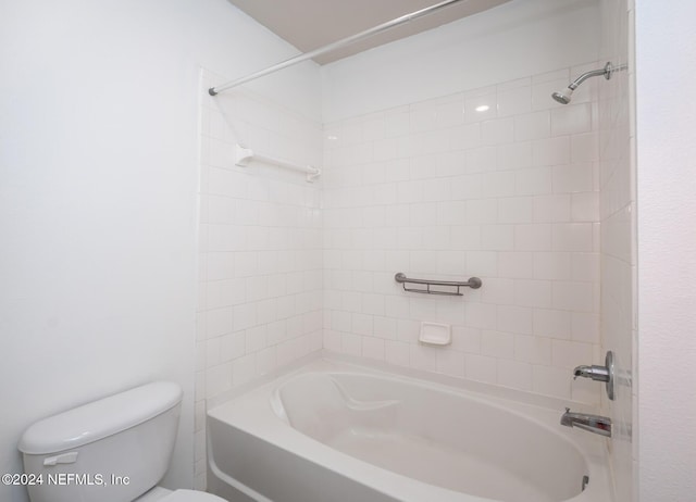 bathroom with tiled shower / bath combo and toilet