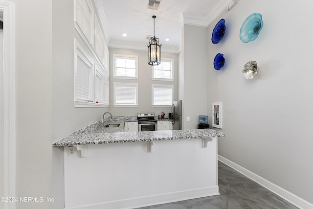 kitchen with sink, stainless steel appliances, kitchen peninsula, decorative light fixtures, and a breakfast bar area