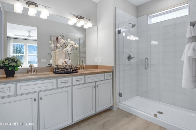 bathroom featuring ceiling fan, plenty of natural light, a shower with door, and hardwood / wood-style flooring