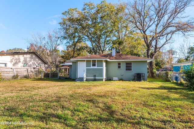 back of house with a yard and central AC unit