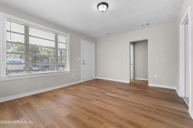 unfurnished room featuring a textured ceiling and hardwood / wood-style flooring